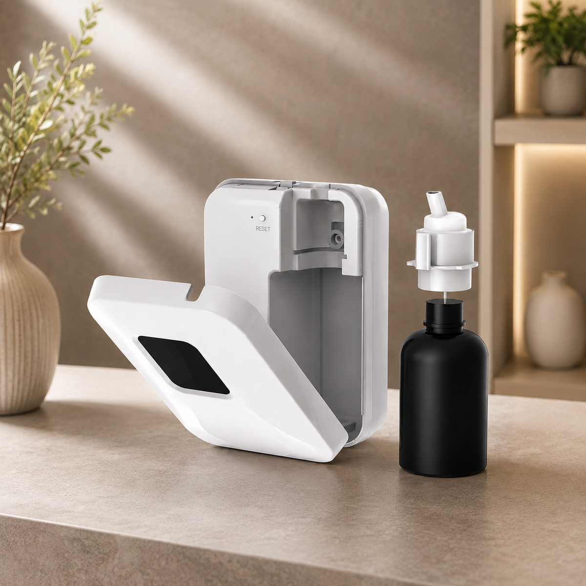 A modern white automatic hand sanitizer dispenser with its door open, shown next to a matte black bottle with a white pump, set on a beige countertop in a warm, sunlit interior.